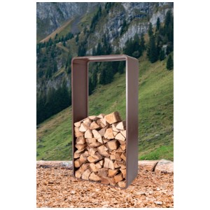 Range-bûches Nouvel en acier couleur rouille rempli de bois, fond de montagne.