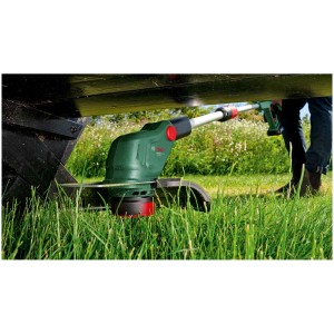 Tagliabordi a batteria Bosch UniversalGrassCut 18V-26-500 che taglia sotto una panca.