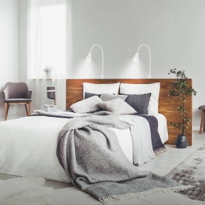 Letto con due lampade da comodino Briloner LED Tuso bianche e orientabili.