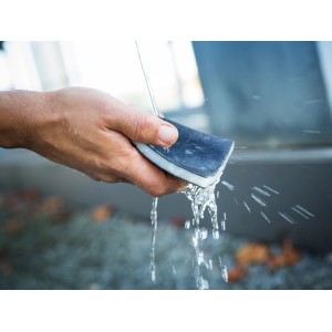 Mano che tiene il set di spugne abrasive LUX sotto l'acqua. Ideale per levigare e lisciare le superfici.