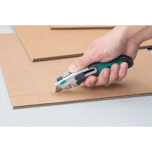 Main coupant du carton avec un cutter de sécurité wolfcraft Profi (lame trapézoïdale).