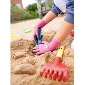 Kind mit pinken Gartenhandschuhen (Größe 4) mit Naturlatex-Beschichtung beim Spielen im Sandkasten.