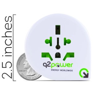 Adaptateur universel UK blanc et noir, 13 A / 250 V, à côté d'une pièce de 25 cents US pour comparaison de taille.