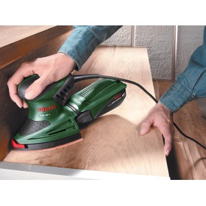 Multisurface Bosch PSM 160 A en action sur du bois, ponceuse pour coins et surfaces.