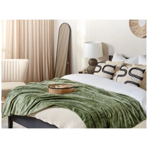 Coperta verde Bayburt in poliestere (150x200 cm) su un letto.