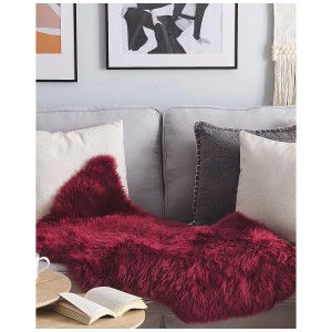 Burgunderroter Schaffell-Teppich Uluru Langhaar (100-110 cm) auf Sofa, für gemütliche Atmosphäre.