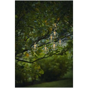 Solar-Lichterkette Chania mit warmweiß leuchtenden Kunststoffkugeln im Garten.