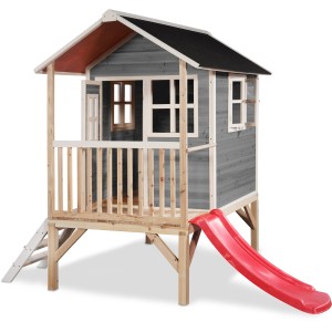 Cabane en bois grise EXIT Loft 300 avec toboggan rouge et échelle sur pilotis.