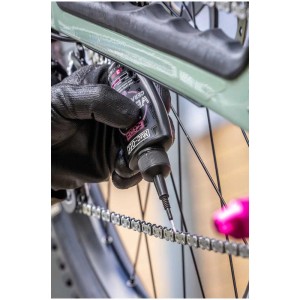 Anwendung von Muc-Off Kettenöl Wet Lube E-Bike auf einer Fahrradkette.