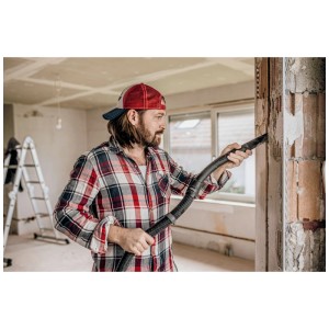 Homme utilisant un aspirateur eau et poussière Kärcher WD 6 P S V-30/8/22/T pour nettoyer un mur sur un chantier.