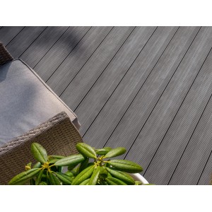 Lames de terrasse Rettenmeier WPC frêne gris, rainurées, avec mobilier de jardin et plante.