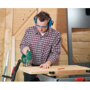 Homme portant un casque antibruit bleu LUX en train de scier du bois pour une protection auditive optimale.