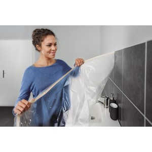 Femme appliquant un film de masquage Tesa avec du ruban adhésif dans la salle de bain. Recharge Easy Cover Economy M.