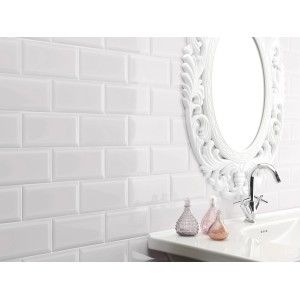 Carrelage mural Facette Metro blanc brillant dans une salle de bain avec lavabo et miroir.