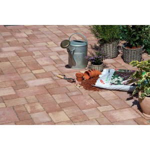 Pavés multi-formats Beton Encanto antique Terra-nuancé posés avec accessoires de jardin.