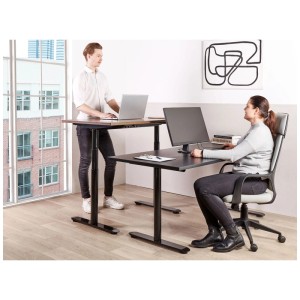 Schwarzer, elektrisch höhenverstellbarer Schreibtisch Destinas. Zeigt ergonomisches Arbeiten im Stehen und Sitzen.