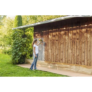Donna che spruzza facciata in legno con Wagner Universal Sprayer W990 Flexio. Spruzzatore di vernice.