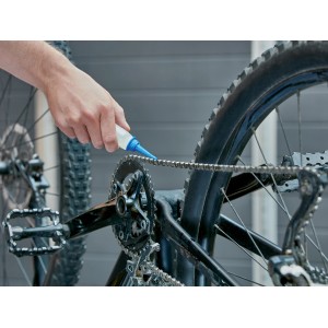 Application d'huile de mécanique de précision sur une chaîne de vélo. Bouteille de 100 ml.
