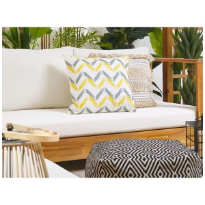 Gartenkissen Affile 2er-Set mit gelb-grauem Zickzack-Muster auf weißem Polyester, 45x45cm, auf Outdoor-Sofa.