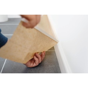Papier de masquage Tesa avec ruban adhésif protégeant les plinthes lors de la peinture.