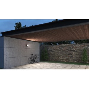 Faretto LED bianco Steinel XLED one su muro di cemento, bicicletta in cortile.