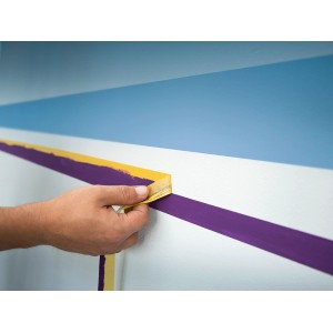 Anwendung von LUX Flachkrepp Exact Line Indoor (25mm) zum Abkleben einer Wand für Farbarbeiten.