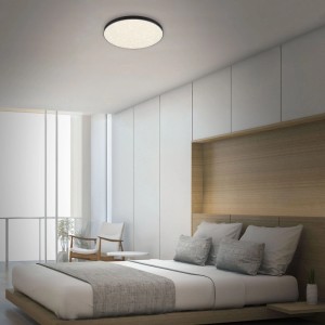 Plafonnier LED Briloner Flame Star, noir, Ø 38,7 cm avec effet ciel étoilé dans une chambre moderne.