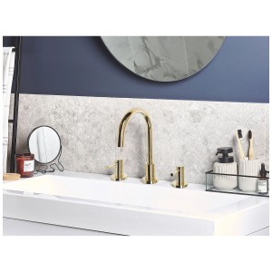 Miscelatore lavabo a 3 fori Sipi in ottone dorato su lavabo bianco.