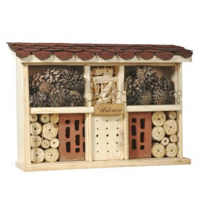 Hôtel à insectes Landhaus Komfort en bois, rempli de matériaux naturels comme des pommes de pin et des branches.