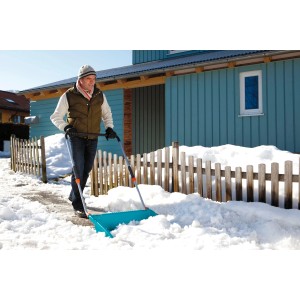 Uomo che spalare la neve con spazzaneve Gardena 70 cm. Spazzaneve con bordo in acciaio per grandi superfici.
