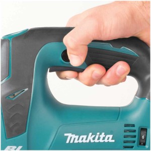 Main actionnant la scie sauteuse sans fil Makita DJV182. Scie sauteuse turquoise et noire.