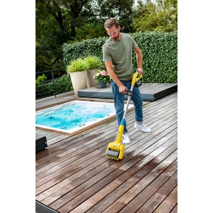 Uomo pulisce patio in legno con spazzola a batteria Gloria MultiBrush. Utensile da giardino per esterni.