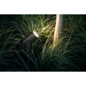 Philips Hue Lily Outdoor Spot, schwarze Gartenleuchte im Beet mit warmweissem Licht.
