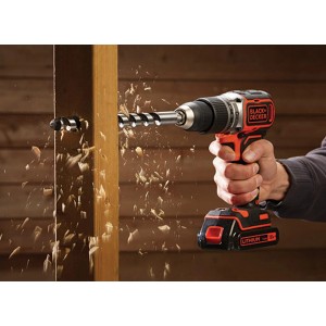 Trapano avvitatore a percussione Black+Decker BL188K che fora il legno, trucioli che volano.