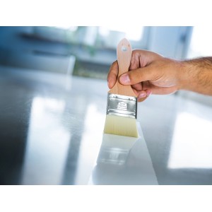 Mano che dipinge la superficie con pennello LUX Finisher (50 mm).