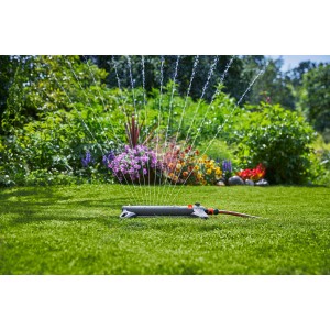 Irrigatore oscillante Gardena AquaZoom S che irriga un prato in giardino.