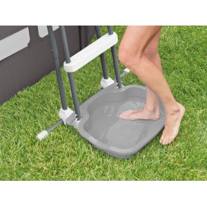 Bain de pieds gris avec échelle pour piscine, pied dans l'eau.