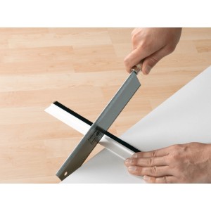 Coupe à la scie du joint de porte blanc Tesamoll Comfort pour sols irréguliers.