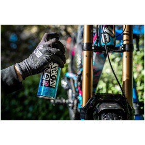 Anwendung: Muc-Off Silicone Shine Pflegespray für Fahrradpflege, 500ml Dose in Hand mit Handschuh.