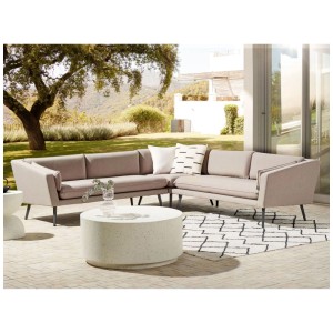 Divano angolare modulare da giardino Beliani Loretello beige per 5 persone su patio con tavolino e tappeto.