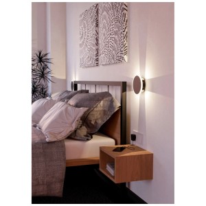 Moderna lampada da parete a LED Talamello rotonda in bianco e nero accanto a un letto in una camera da letto.