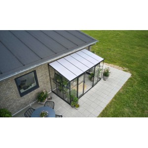 Serra da appoggio Halls Qube Lean-to 612 nera con vetro frontale e piante sul patio.