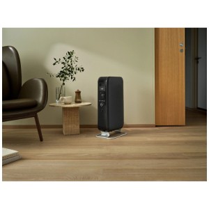 Radiatore a olio Mill Gentle Air WiFi nero 1500W in soggiorno moderno su pavimento in legno con display digitale.