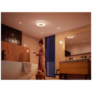 Plafonnier LED blanc Philips Hue Xamento dans une salle de bain avec éclairage d'ambiance coloré.