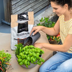 Femme remplissant un pot avec la pelle Lechuza Pon gris ardoise. Accessoires pour pots.