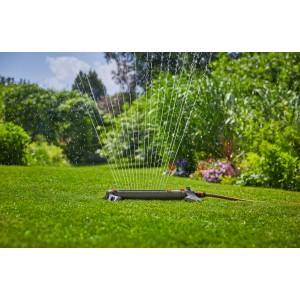 Irrigatore oscillante Gardena AquaZoom L che innaffia il prato in giardino.