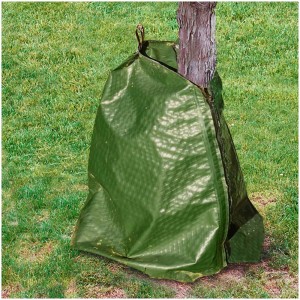 Sac d'arrosage Videx Garden Rainbag vert (75 l) autour d'un tronc d'arbre dans le jardin.