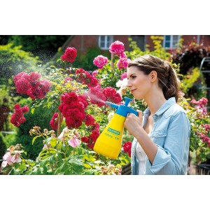 Femme utilisant le pulvérisateur à pression Gloria Hobby 100 pour l'entretien des plantes dans le jardin.