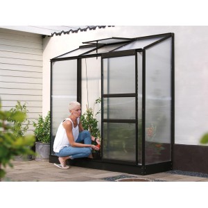 Serre Vitavia Ida 1300, serre adossée noire avec porte ouverte et femme devant.