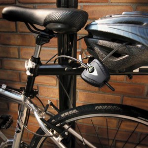 Antivol câble Python Master Lock noir fixé au vélo, sécurisant le casque.
